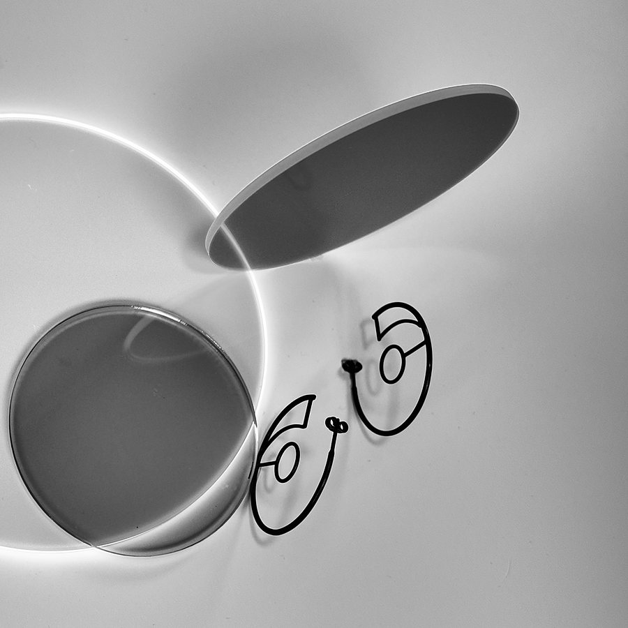 Black wire hoop earrings with a drawn line and dots, black and white photo