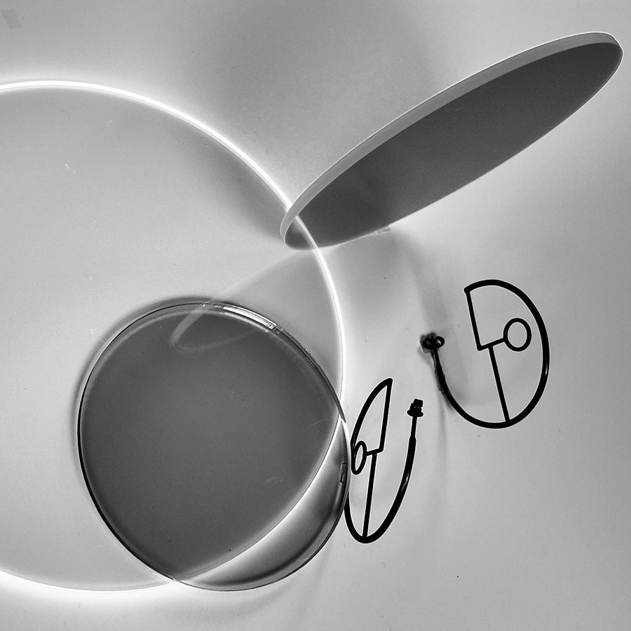 Black wire hoop earrings seen from above, with discs casting a bright ring of light