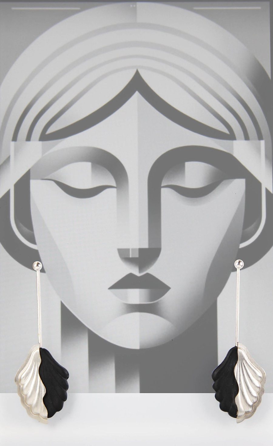 Earrings with a silver leaf and a matte black acrylic leaf on a long oxidized silver bar, in front of an art deco face illustration